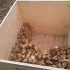 Waterproof bin being loaded with dried hardwood.